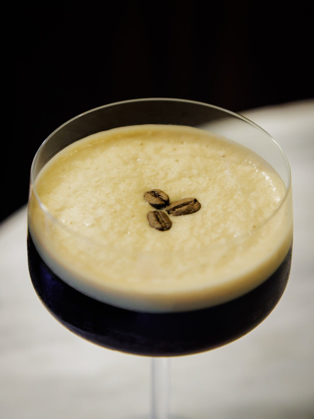 An espresso martini topped with three coffee beans